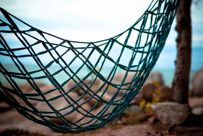 Close-up of metallic ball on land against sky