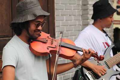 Young man playing violin at street music concert