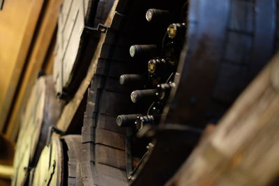 Low angle view of wine bottles in barrels at cellar