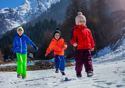 Rear view of people walking on snow