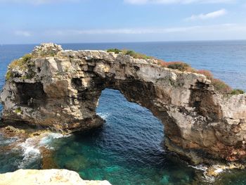 Rock formations by sea against sky