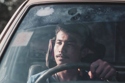 Portrait of man seen through car window