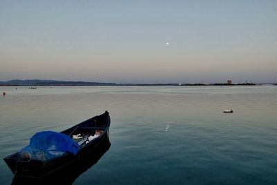 Boat moored on sea against clear sky