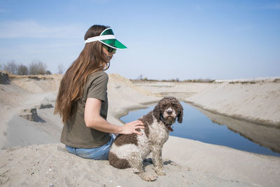 Young woman enjoying by the water in company of her dog