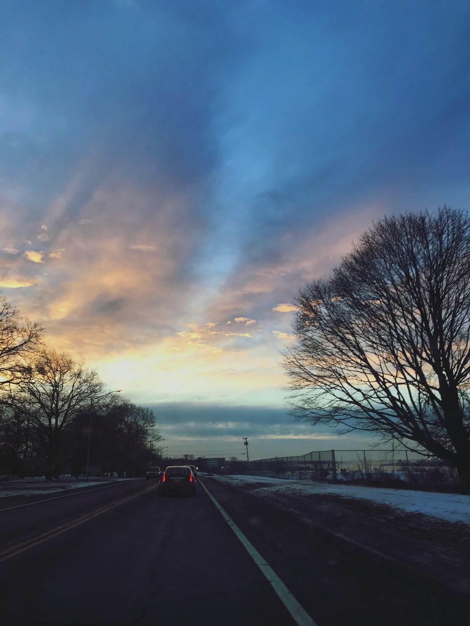 ROAD AMIDST BARE TREES DURING WINTER