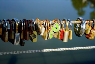 Close-up of padlocks hanging on metal against sky