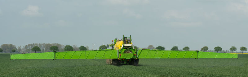 Tractor with field sprayer when applying pesticide against pesticide