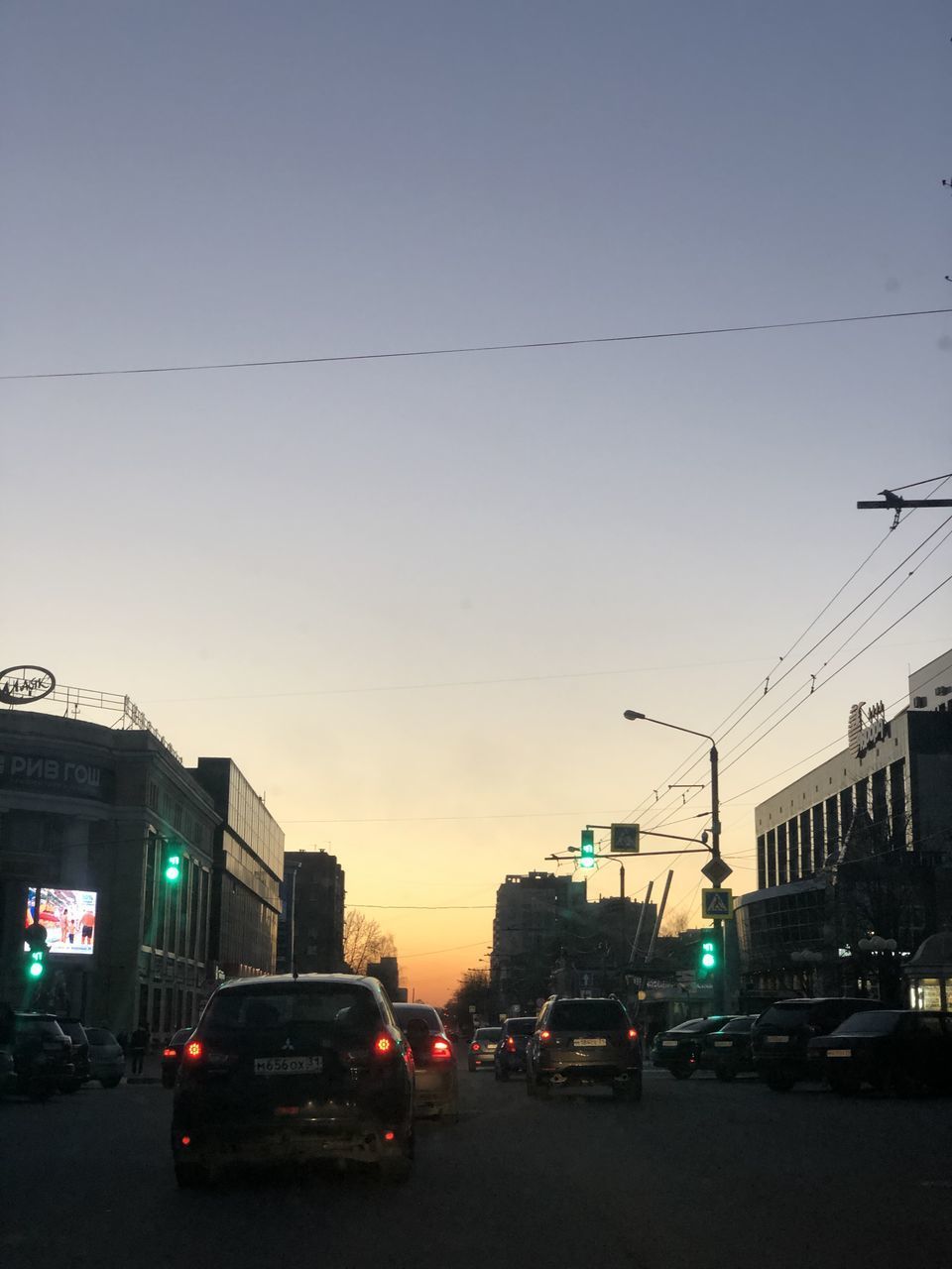 TRAFFIC ON CITY STREET AGAINST SKY AT DUSK