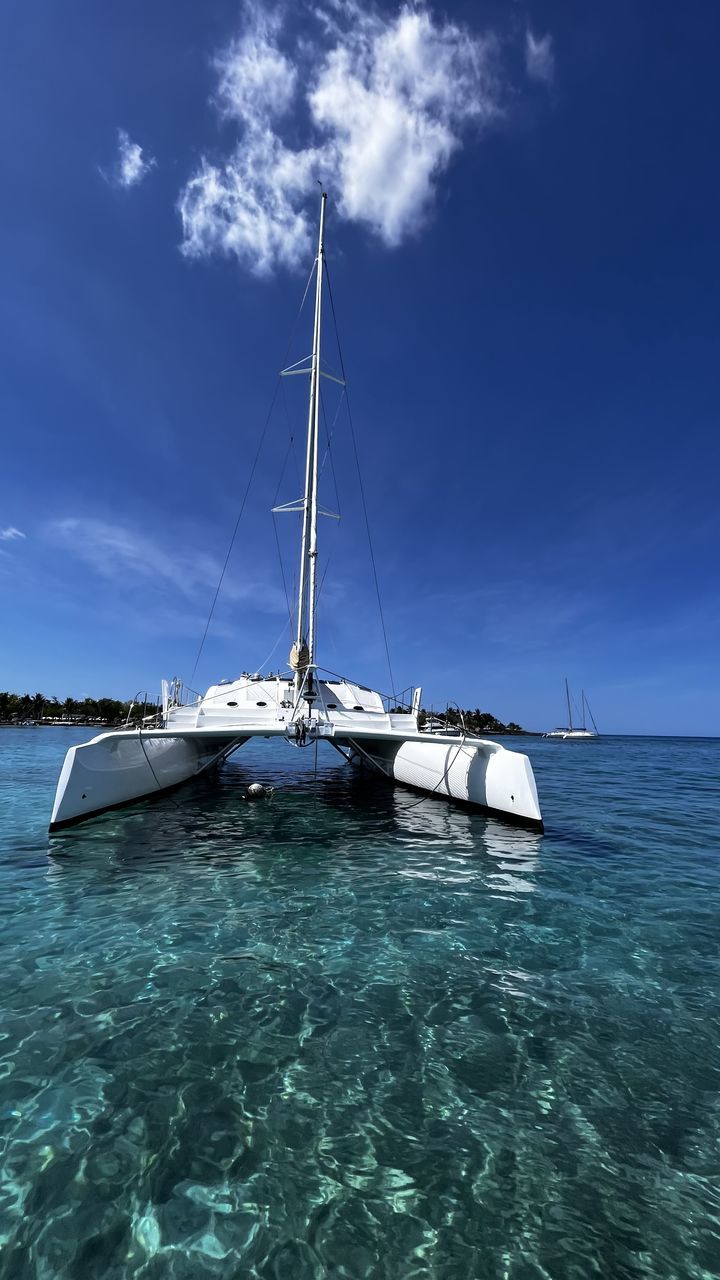 water, nautical vessel, sea, transportation, sailboat, mode of transportation, sky, sailing, cloud, nature, vehicle, ocean, blue, travel, ship, sailing ship, boat, beauty in nature, mast, pole, yacht, holiday, no people, vacation, scenics - nature, watercraft, luxury, travel destinations, outdoors, trip, tranquility, environment, day, idyllic, tranquil scene, land, coast, tropical climate, beach, bay, tourism, yachting