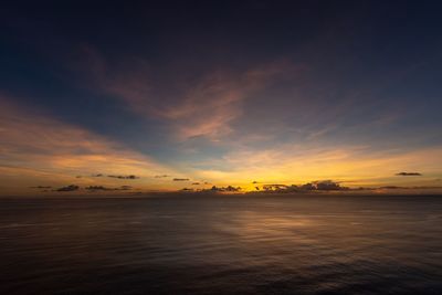 Scenic view of sea against dramatic sky during sunset