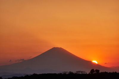 Scenic view of silhouette mountains against romantic sky at sunset