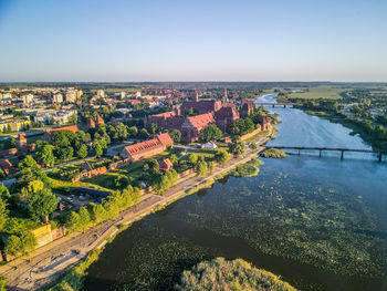 High angle view of river by buildings in city against clear sky