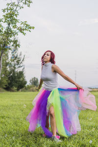 Woman dancing on field against trees