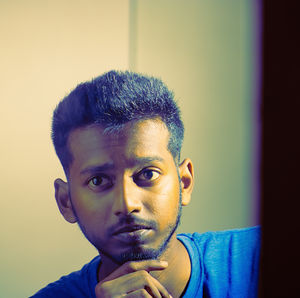 Close-up portrait of young man against wall