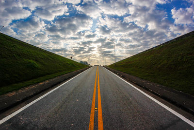 Country road against sky