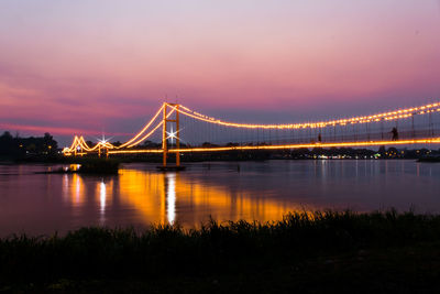 Bridge over river at sunset