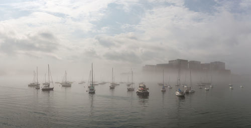 Sailboats sailing in sea against sky