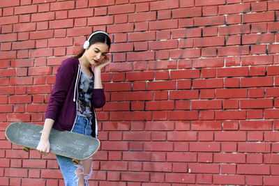 Woman standing against brick wall