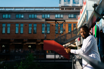 Side view of man standing in front of building