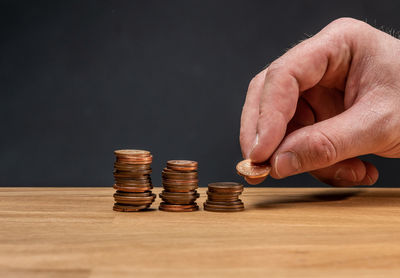 Close-up of hand holding stack of objects on table