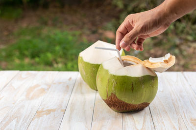 Fresh coconut on a wooden table with natural backdrop