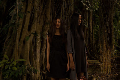 Portrait of young woman standing in forest