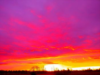 Silhouette landscape against dramatic sky during sunset