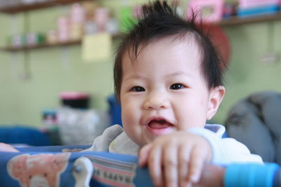 Close-up portrait of cute baby girl in crib at home