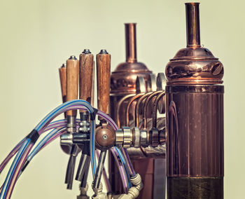 Close-up of beer taps against colored background