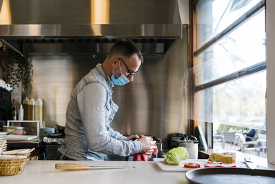 Waiter with protective face mask working in restaurant