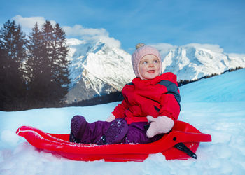 Portrait of young woman skiing on snow covered mountain