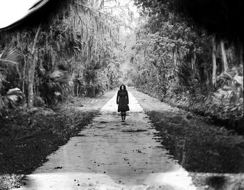 Rear view of people walking on footpath