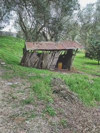 Wooden house on field by trees