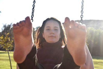 Portrait of boy on swing in playground