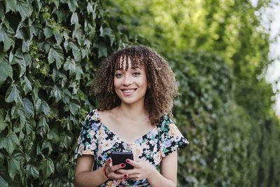 Portrait of smiling young woman standing outdoors