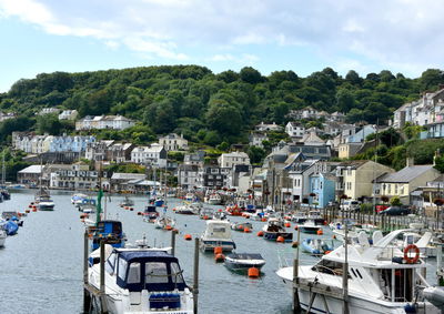 Boats moored in harbor by buildings in city