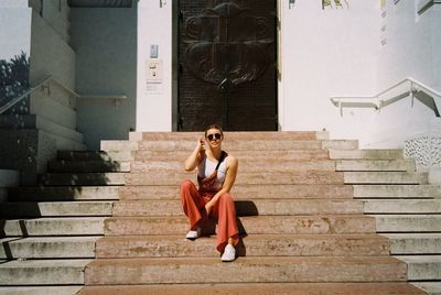 Full length of woman sitting on staircase