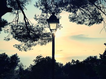 Low angle view of street light against sky at sunset