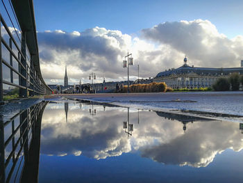 Reflection of clouds on water in city