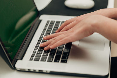 Cropped hands using laptop on table