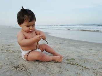 Rear view of a baby sitting on beach