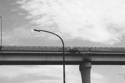 Low angle view of bridge against cloudy sky