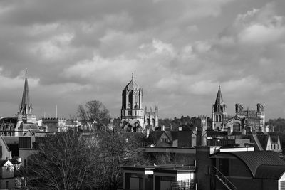 Buildings in city against cloudy sky