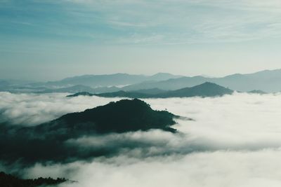 Scenic view of clouds covering mountains against sky