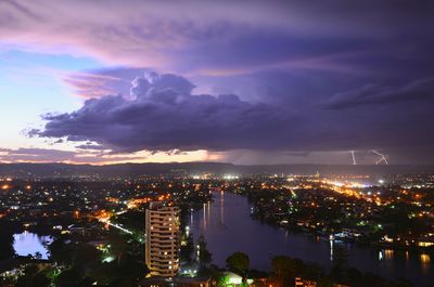 Illuminated cityscape against sky at night