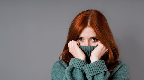 Portrait of young woman against white background