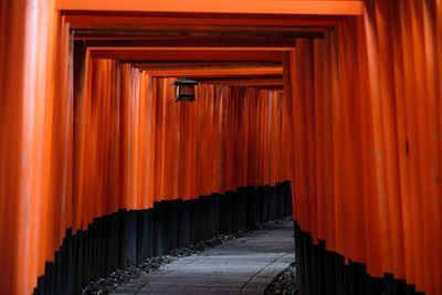 Row of footpath by building against orange sky
