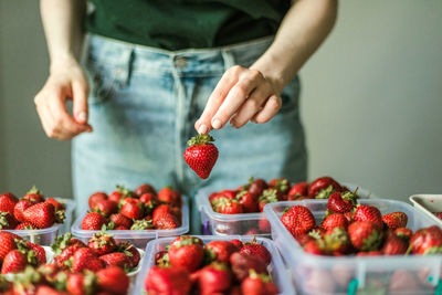 Midsection of woman holding strawberries