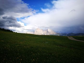 Scenic view of green landscape and mountains against sky