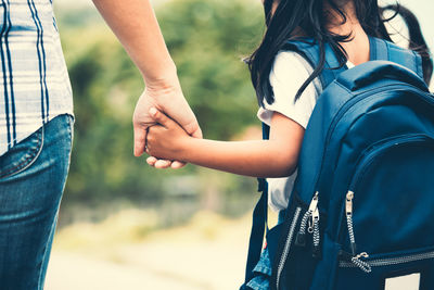 Midsection of couple holding hands